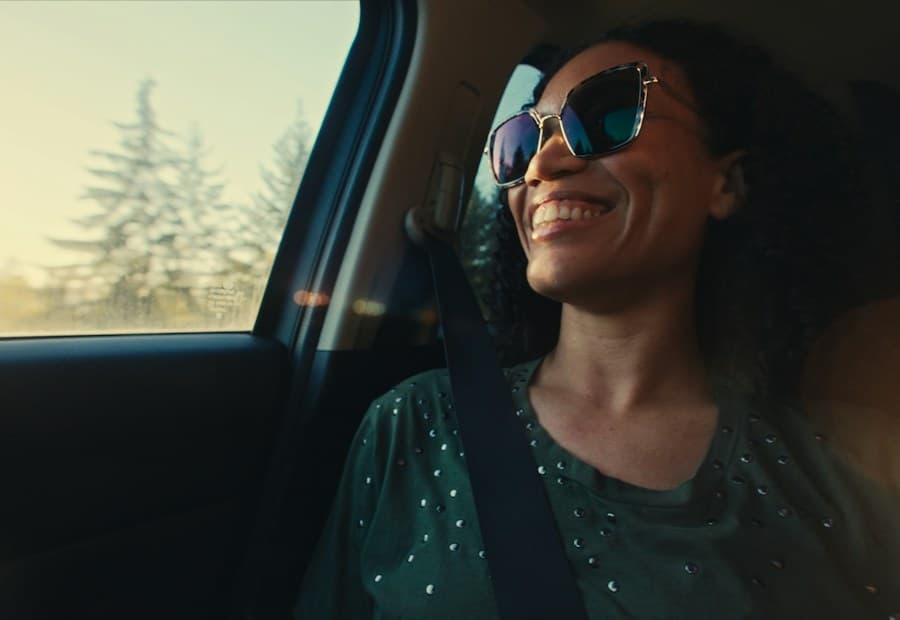 A woman in sunglasses smiling on a drive