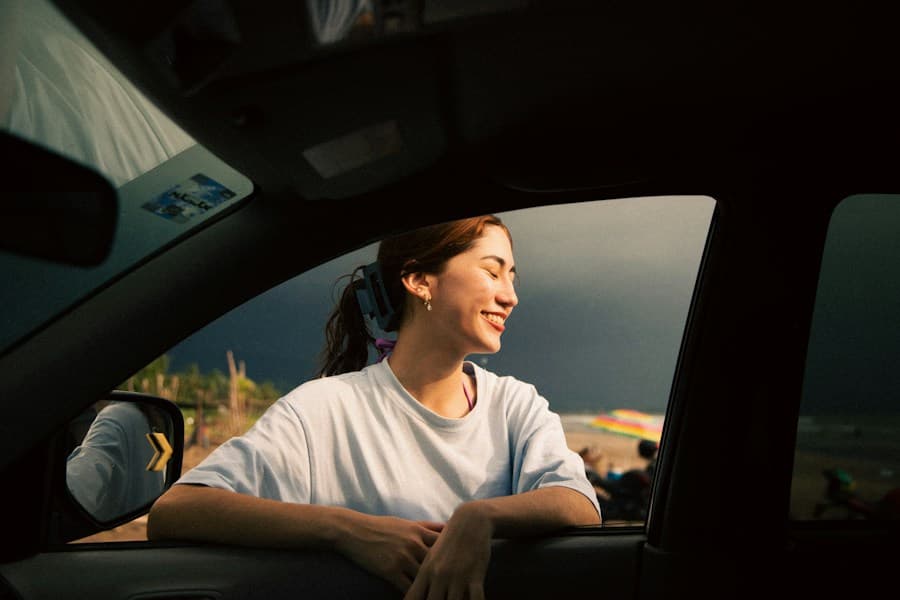 A young woman smiling out of a car window
